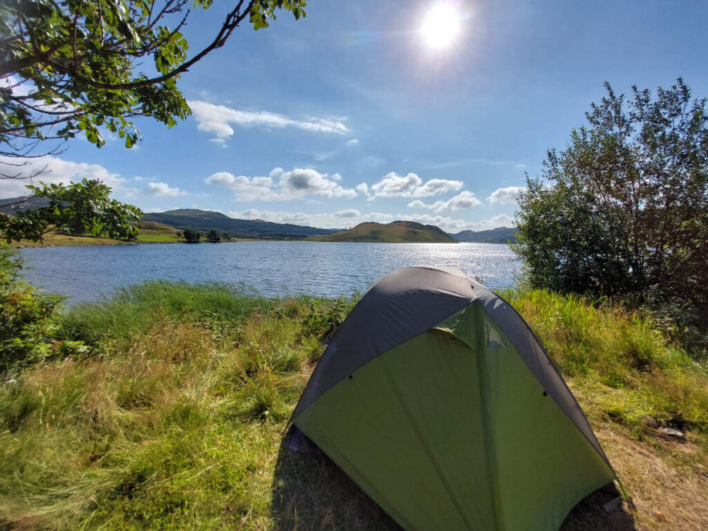 Tent bij meer met zon