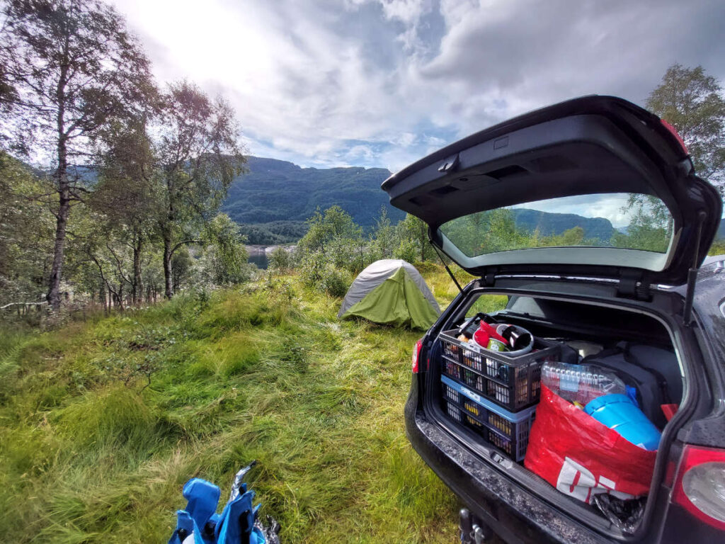 Volgepakte auto met tent op de achtergrond
