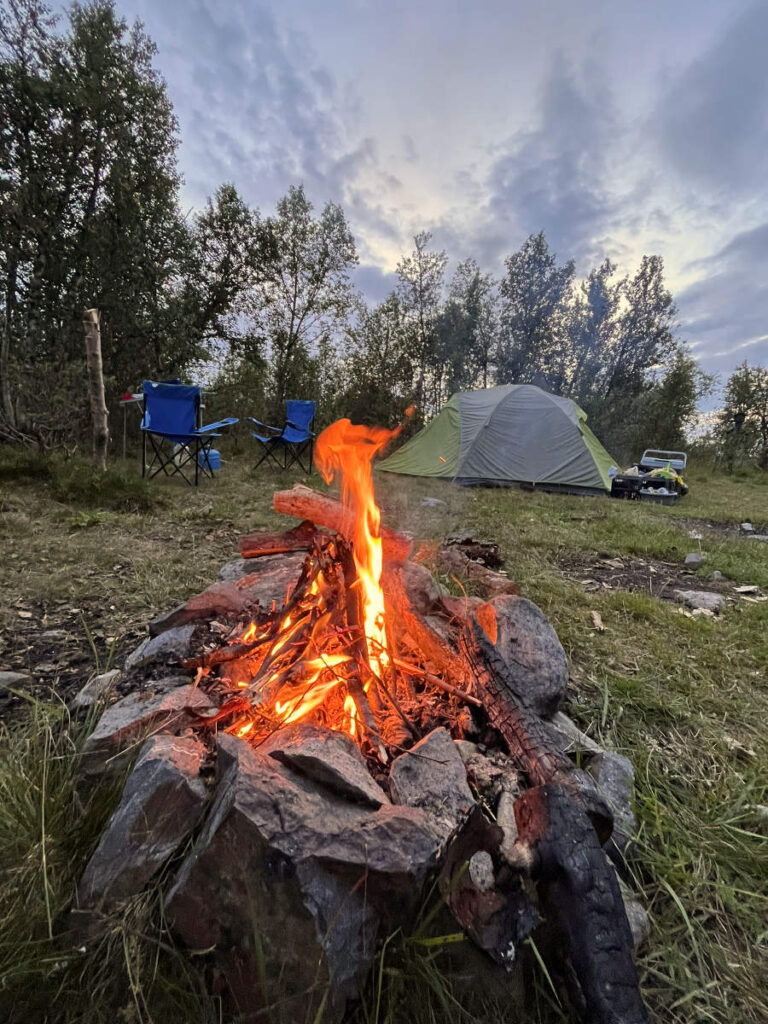 Kampvuur met tent op achtergrond tijdens wildkamperen Noorwegen